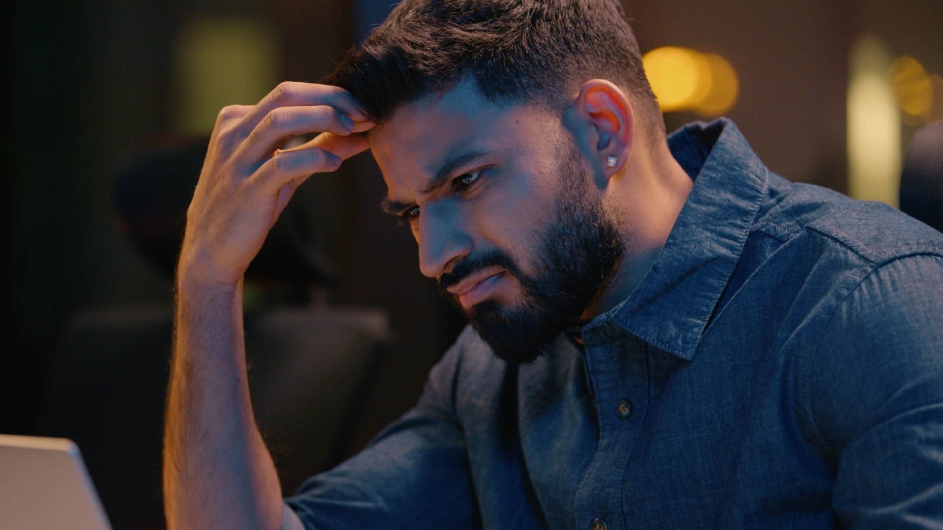 frustrated man looking at overly complex health insurance on his laptop