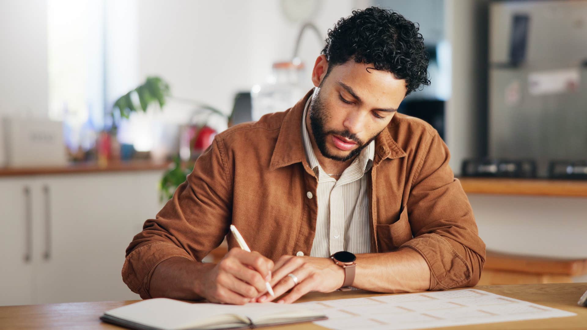 busy millennial man trying to scheduling hang-outs with friends in his calendar