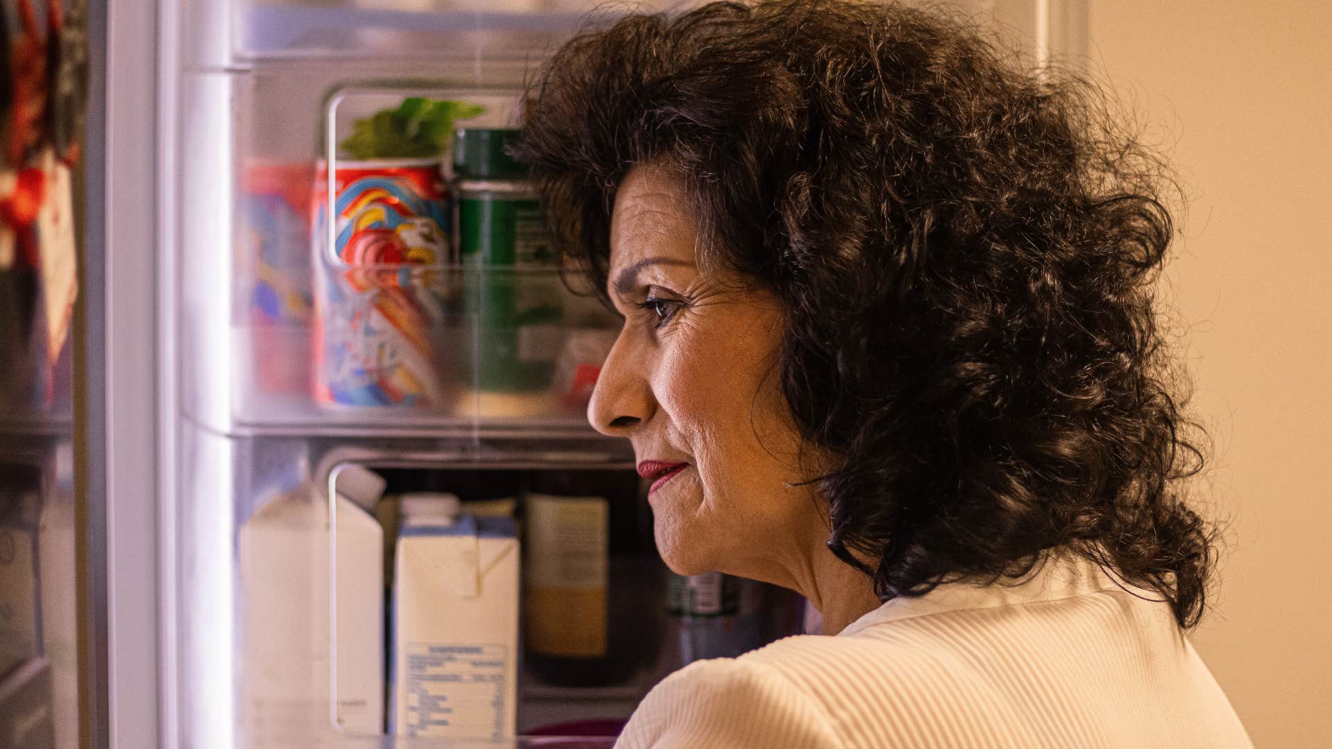 older woman looking sad in fridge