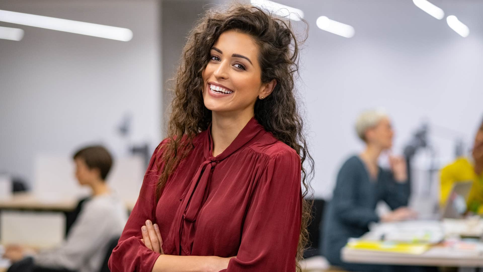 woman faking a smile and laugh at work