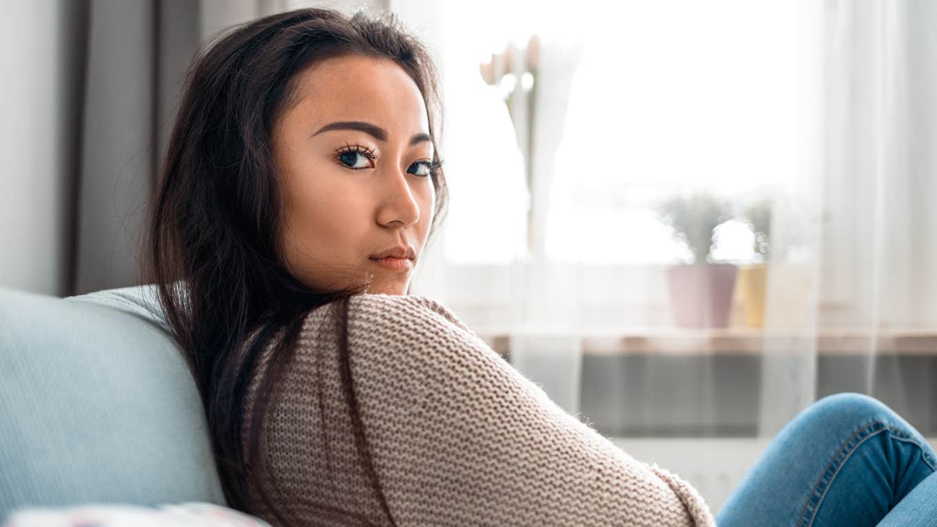 stressed out woman sitting on her couch at home