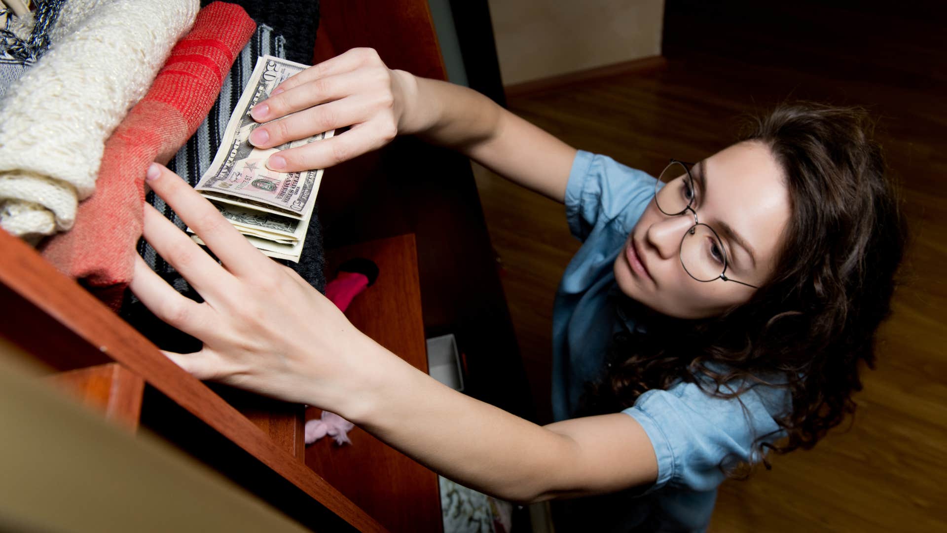 wealthy woman reaching for a stash of cash