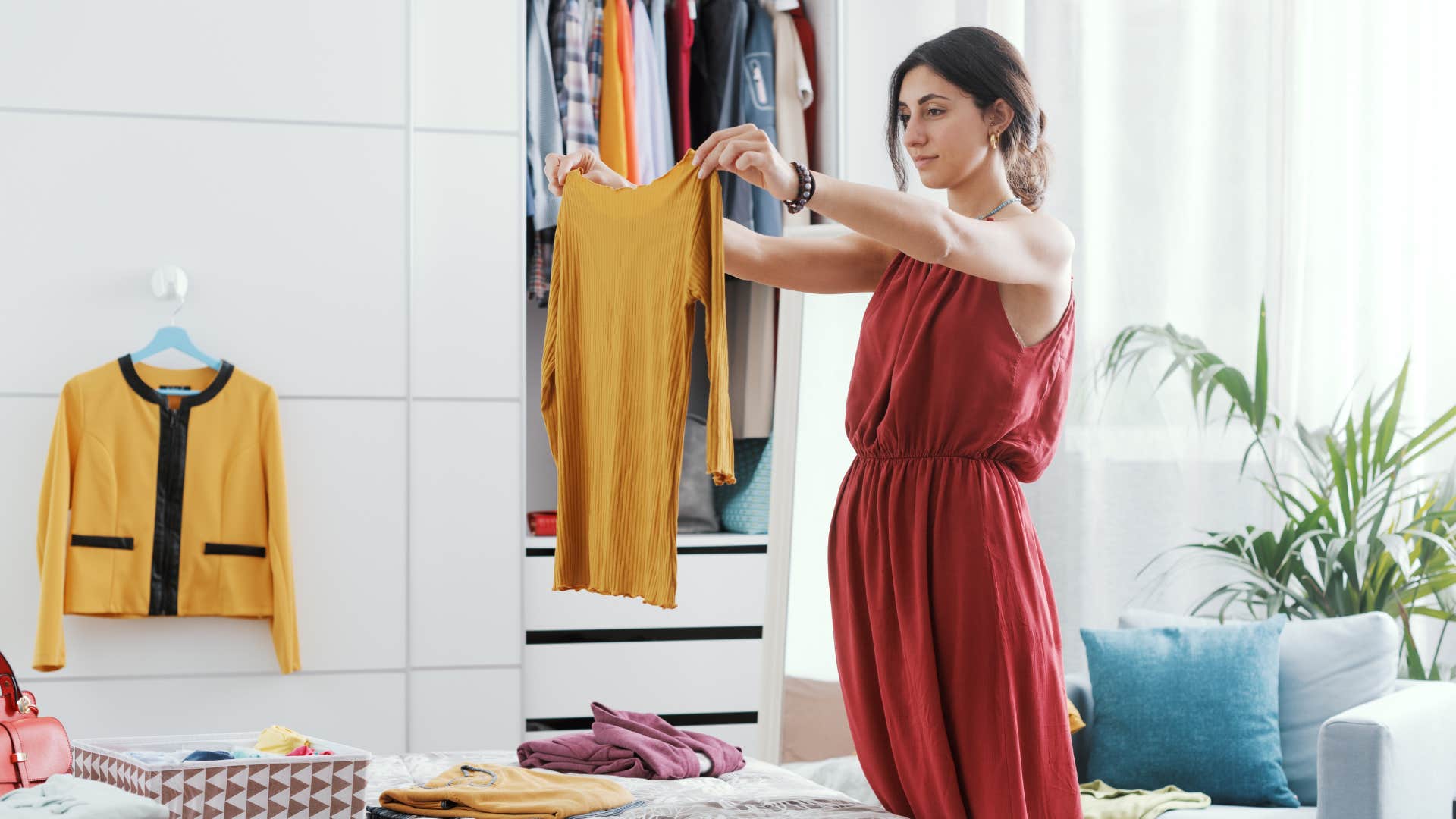 wealthy woman looking through her clothes in closet