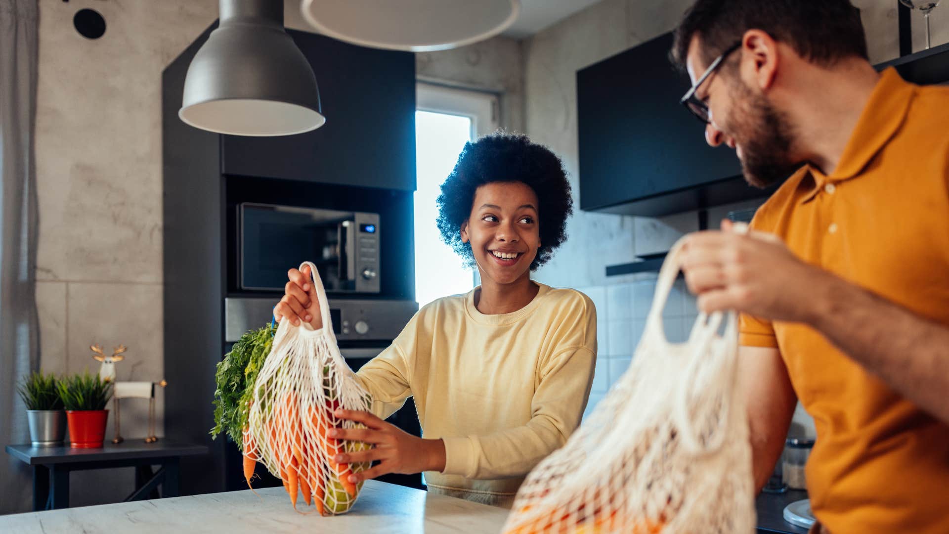 woman smiling with husband unloading groceries