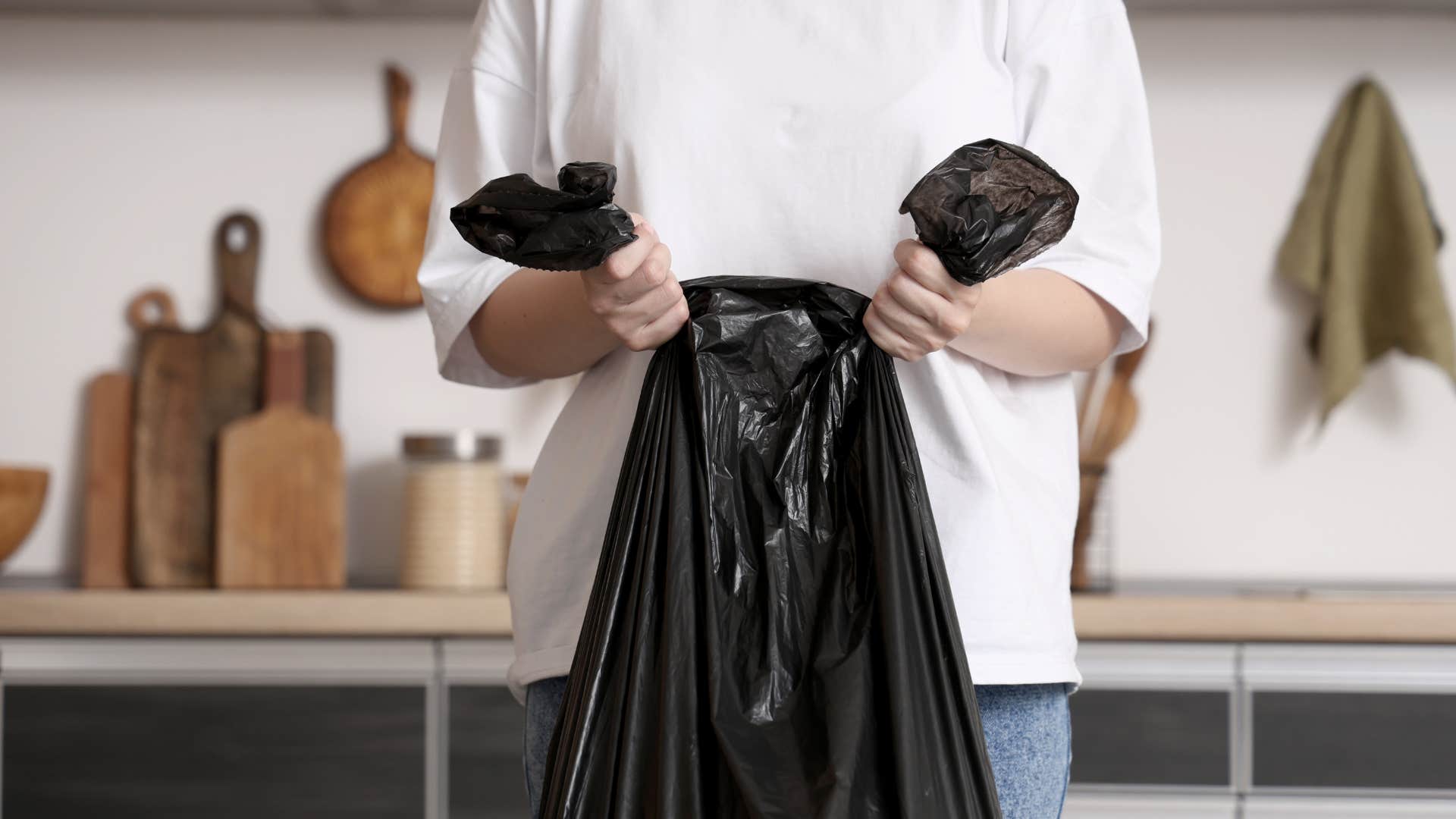woman tying up trash bag to throw out