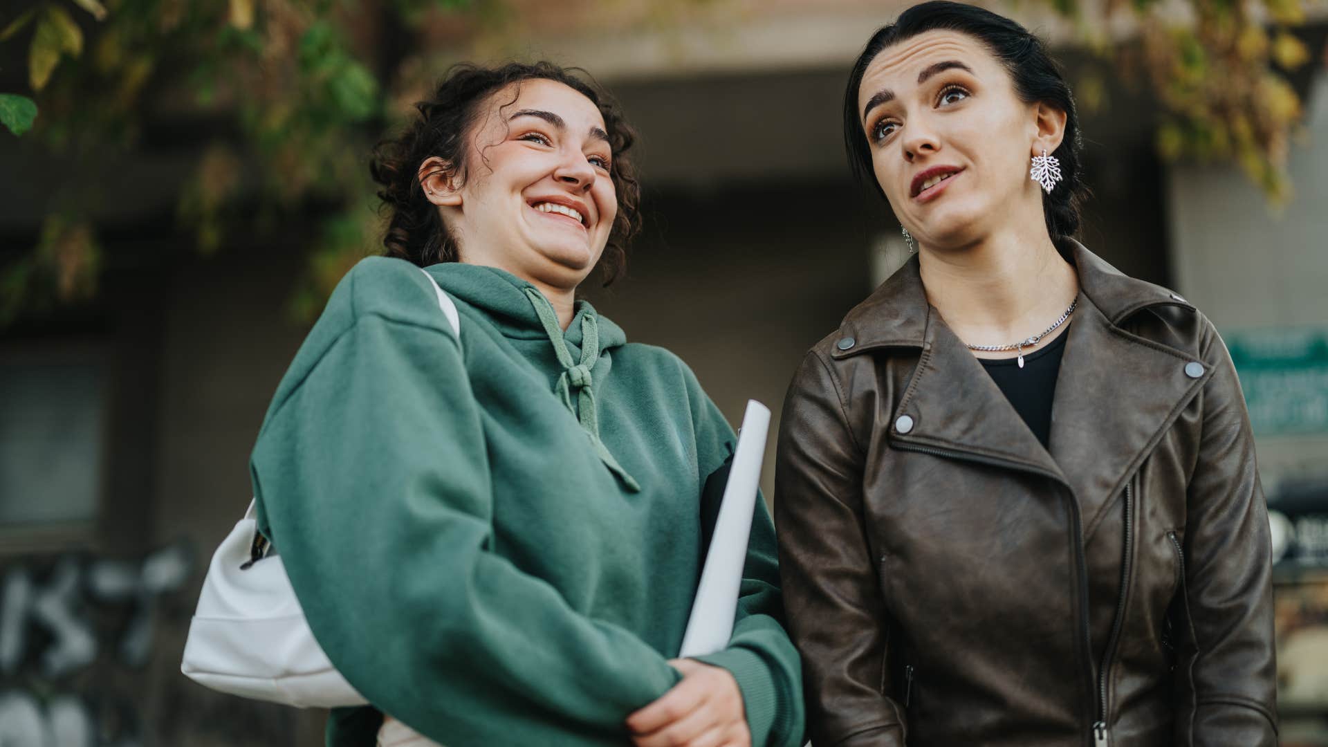 woman whose humor is recycled from other people laughing with a friend