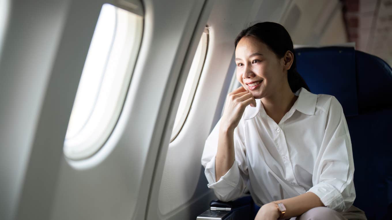 woman sitting next to window on plane