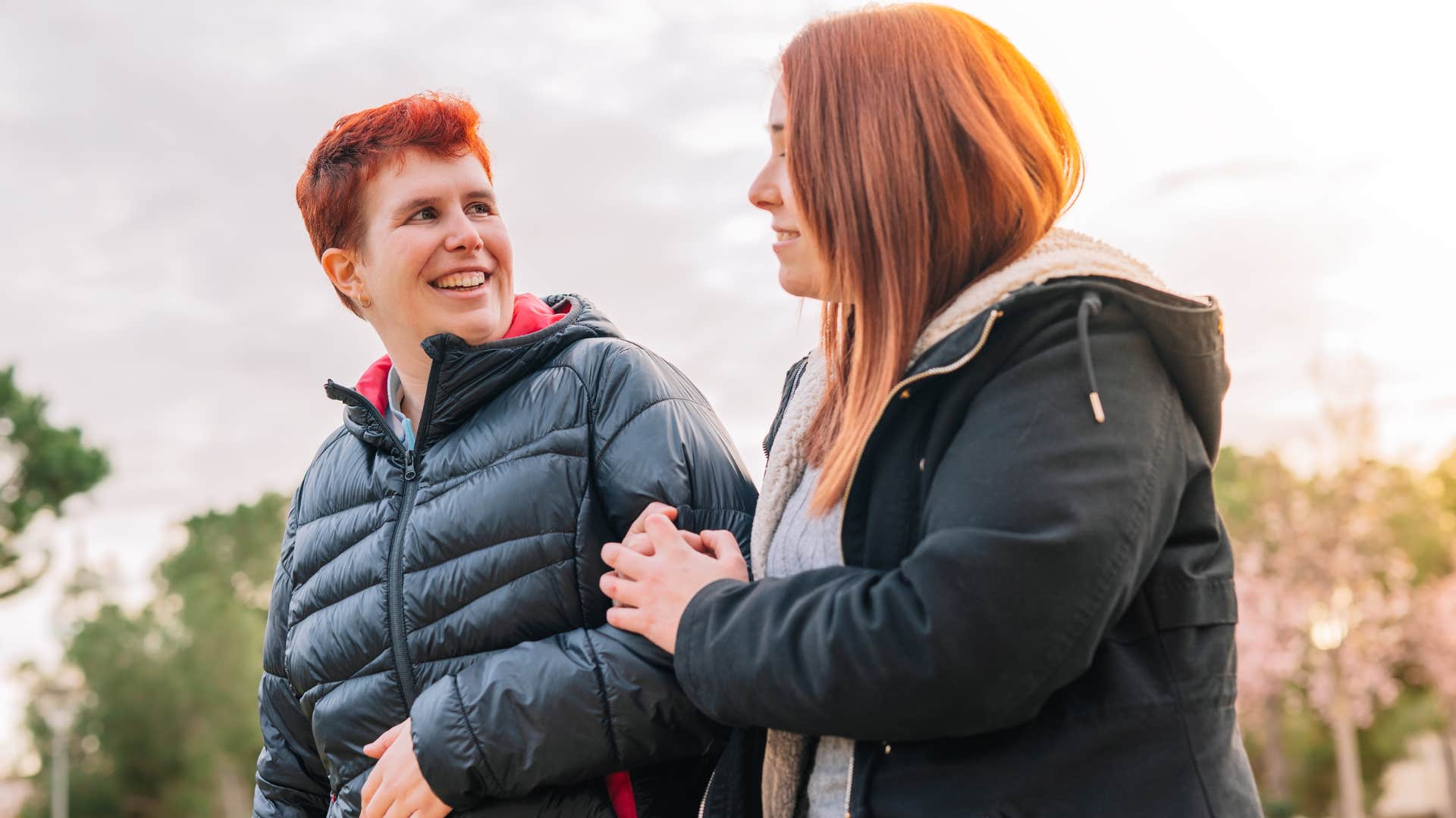 woman hanging onto partner's sleeve outside