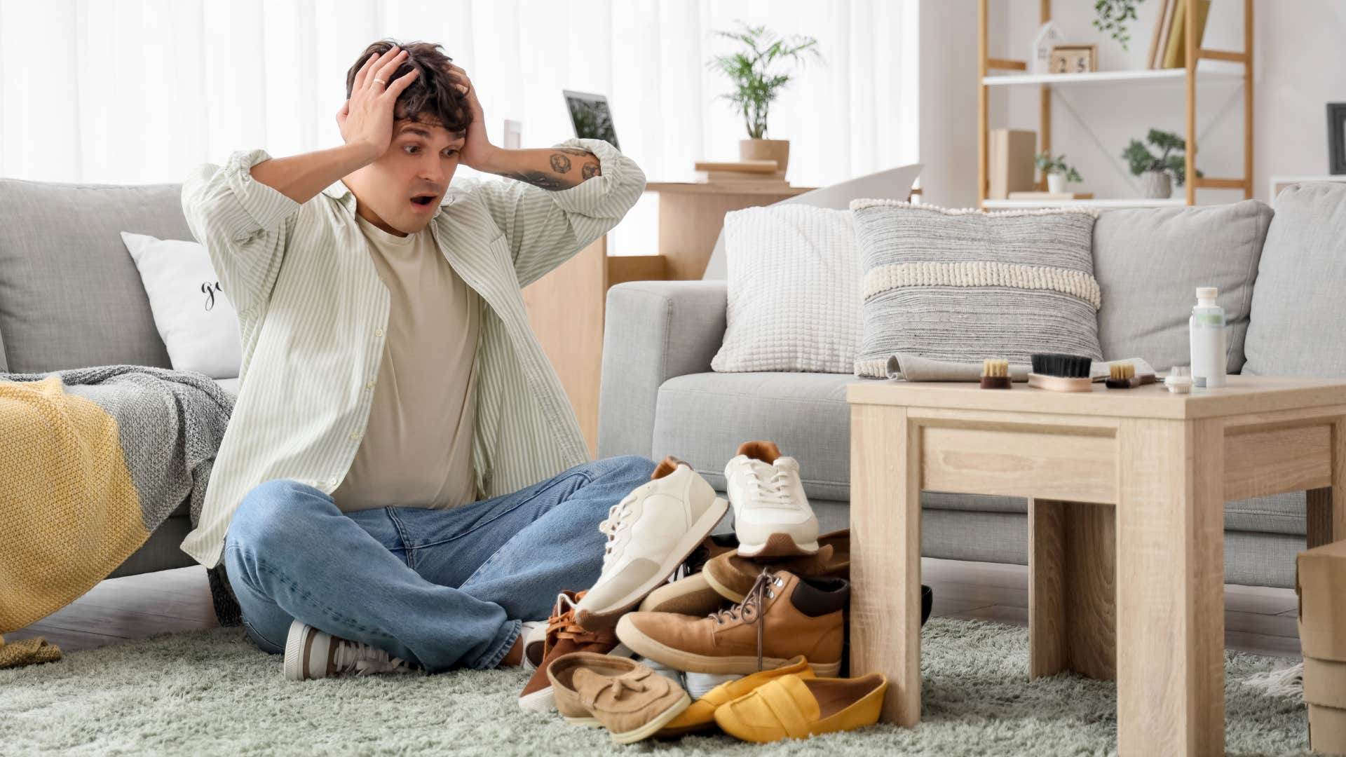 stressed man looking at shoe pile