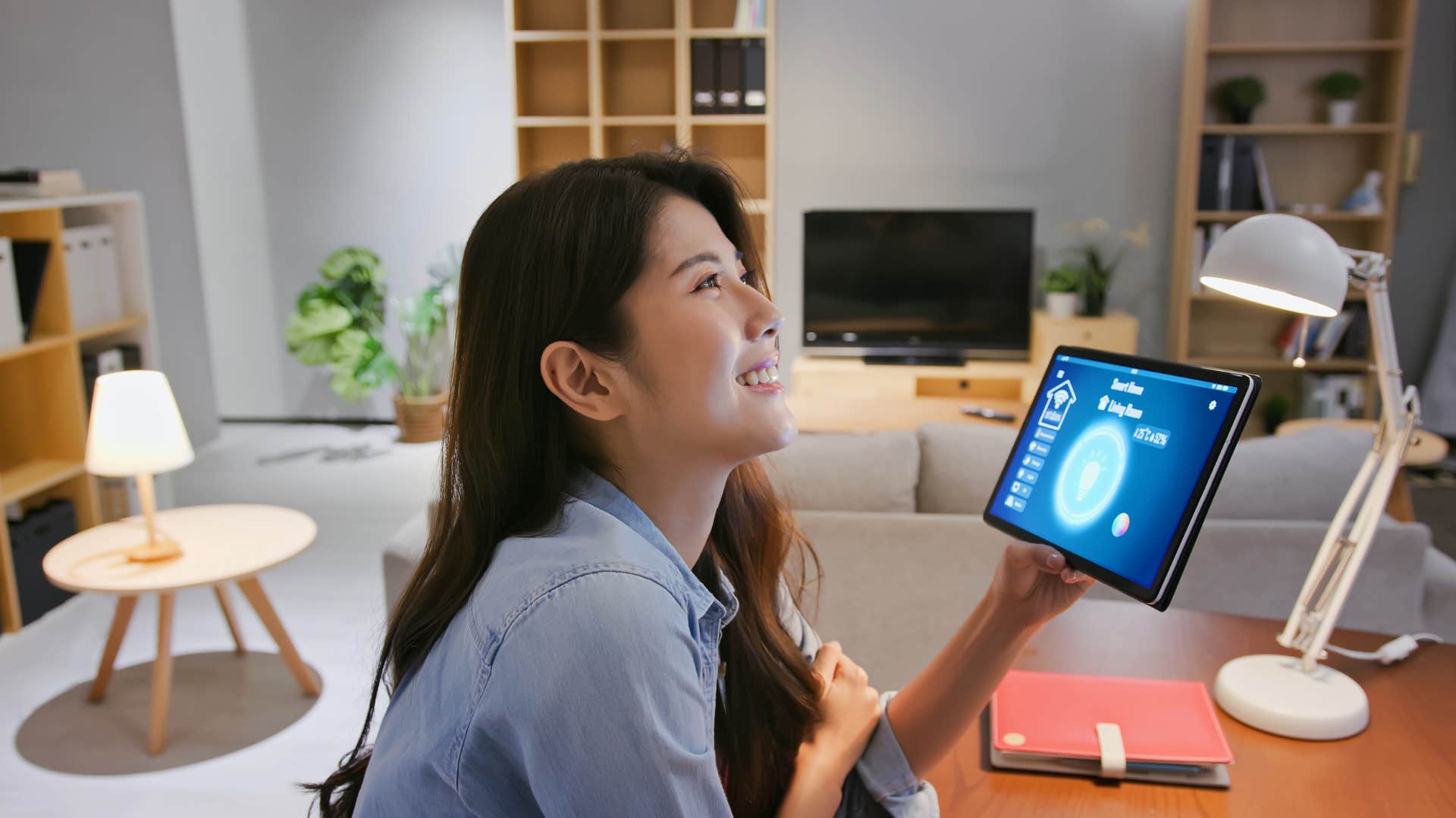 woman using ipad to turn on all lights in house