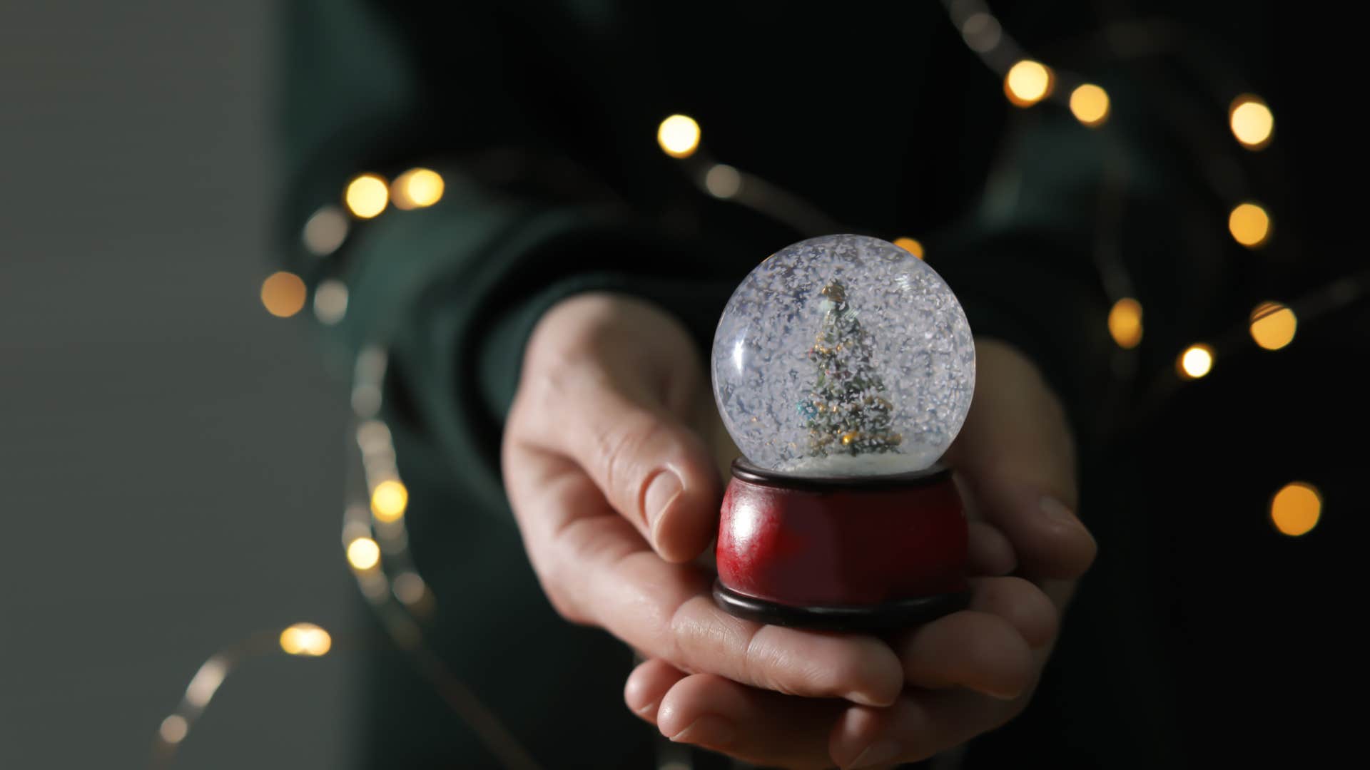 woman holding mini snow globe from her childhood