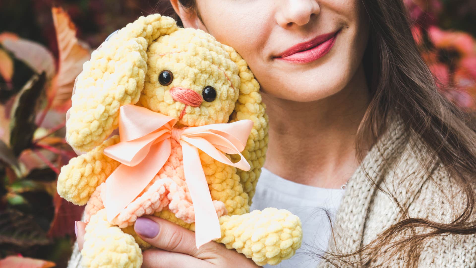 smiling woman holding stuffed animal