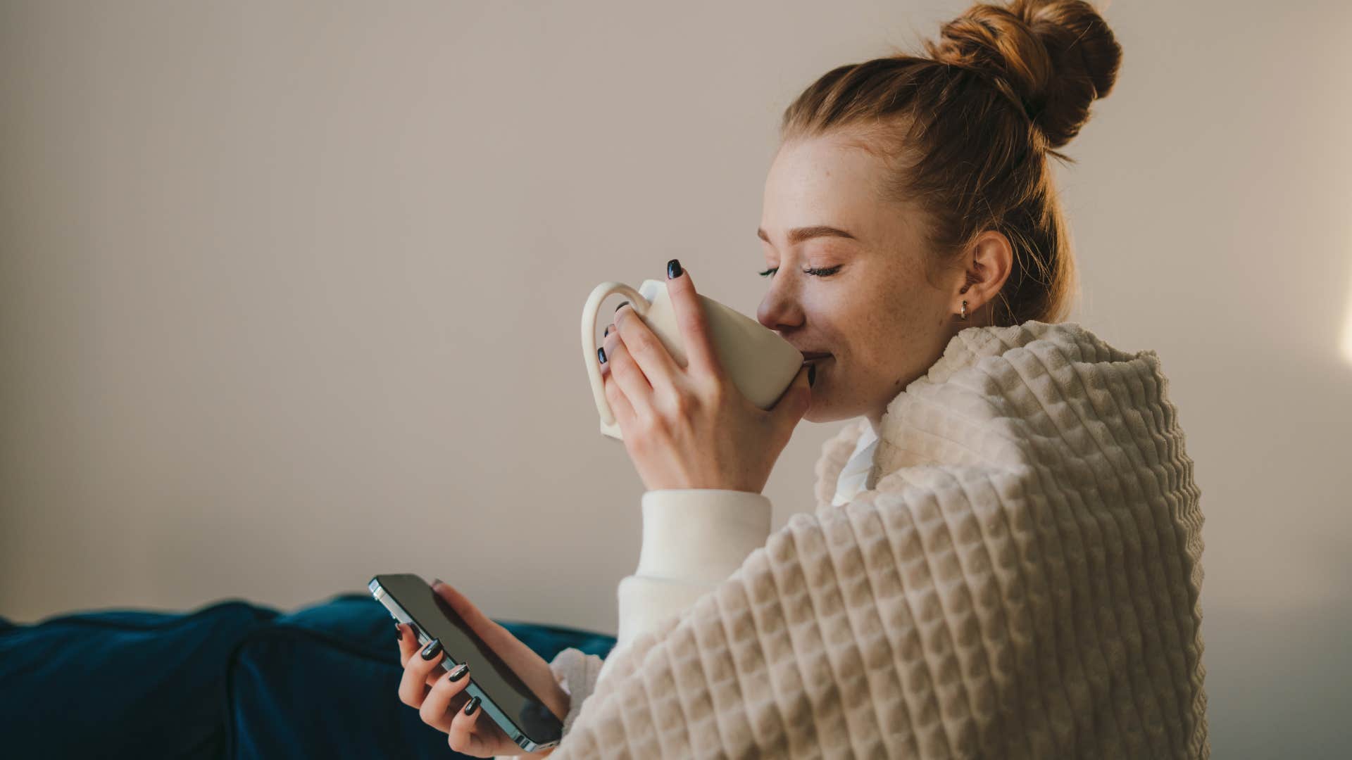 woman drinking tea with weighted blanket on her