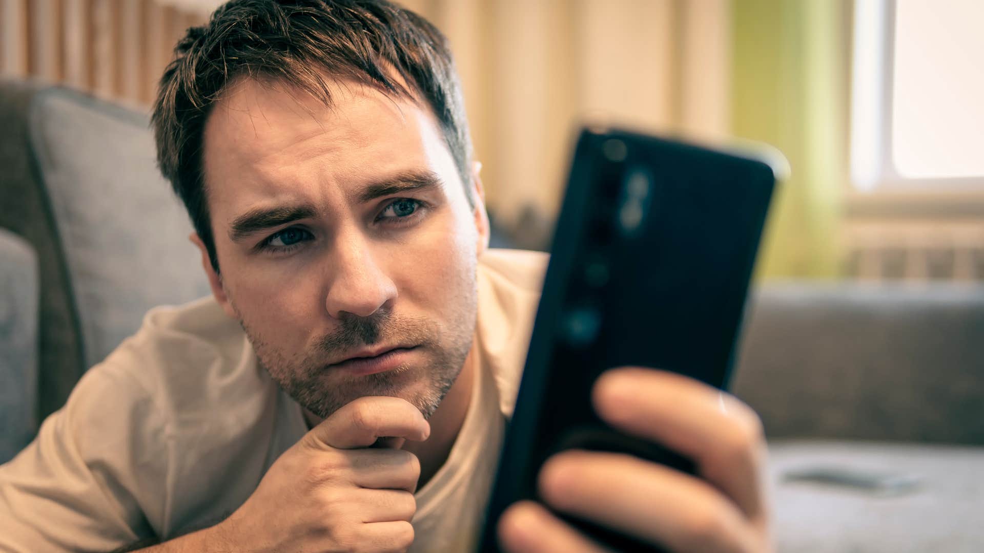 man looking at phone texting not trusting people easily