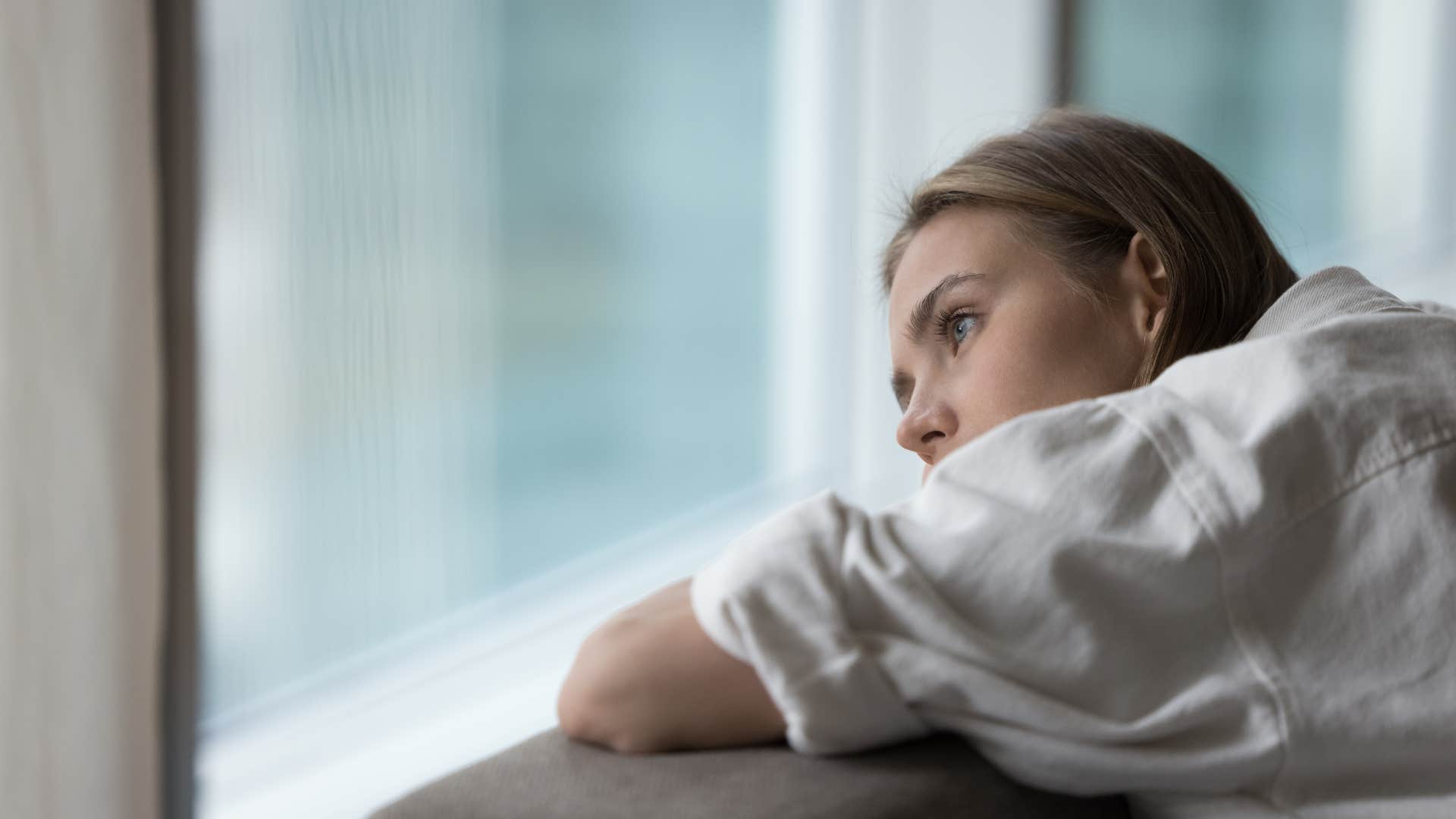 woman staring out the window anxiously