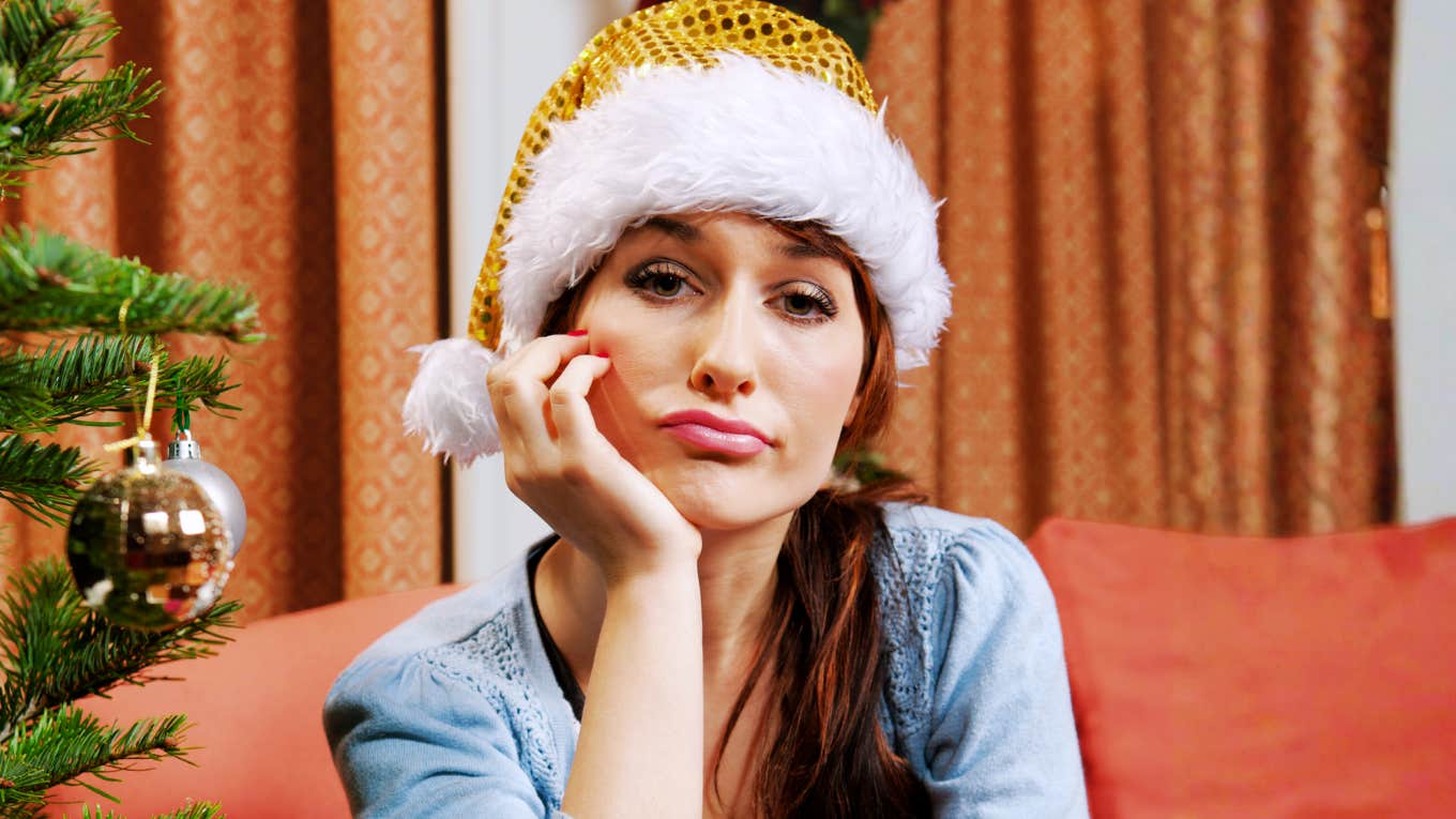 Sad woman wearing a Santa hat at Christmas, reflecting the habits that cause relationships to fall apart during the holidays.