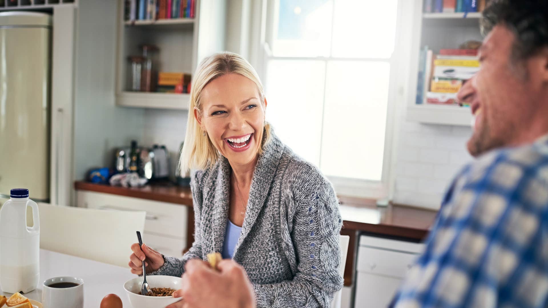 couple sitting at the table eating together and laughing as they have effortless companionship