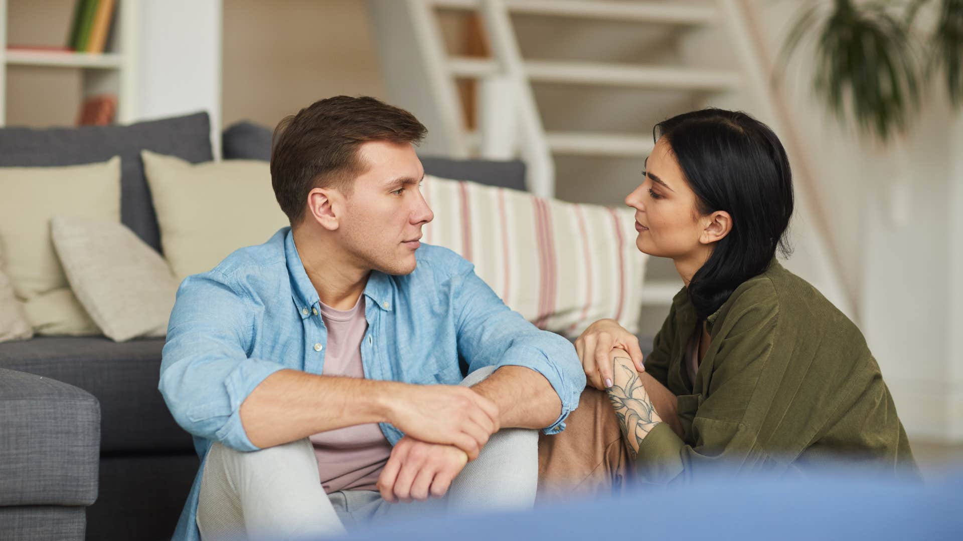 couple on the floor looking at one another as there's a quiet unspoken safety