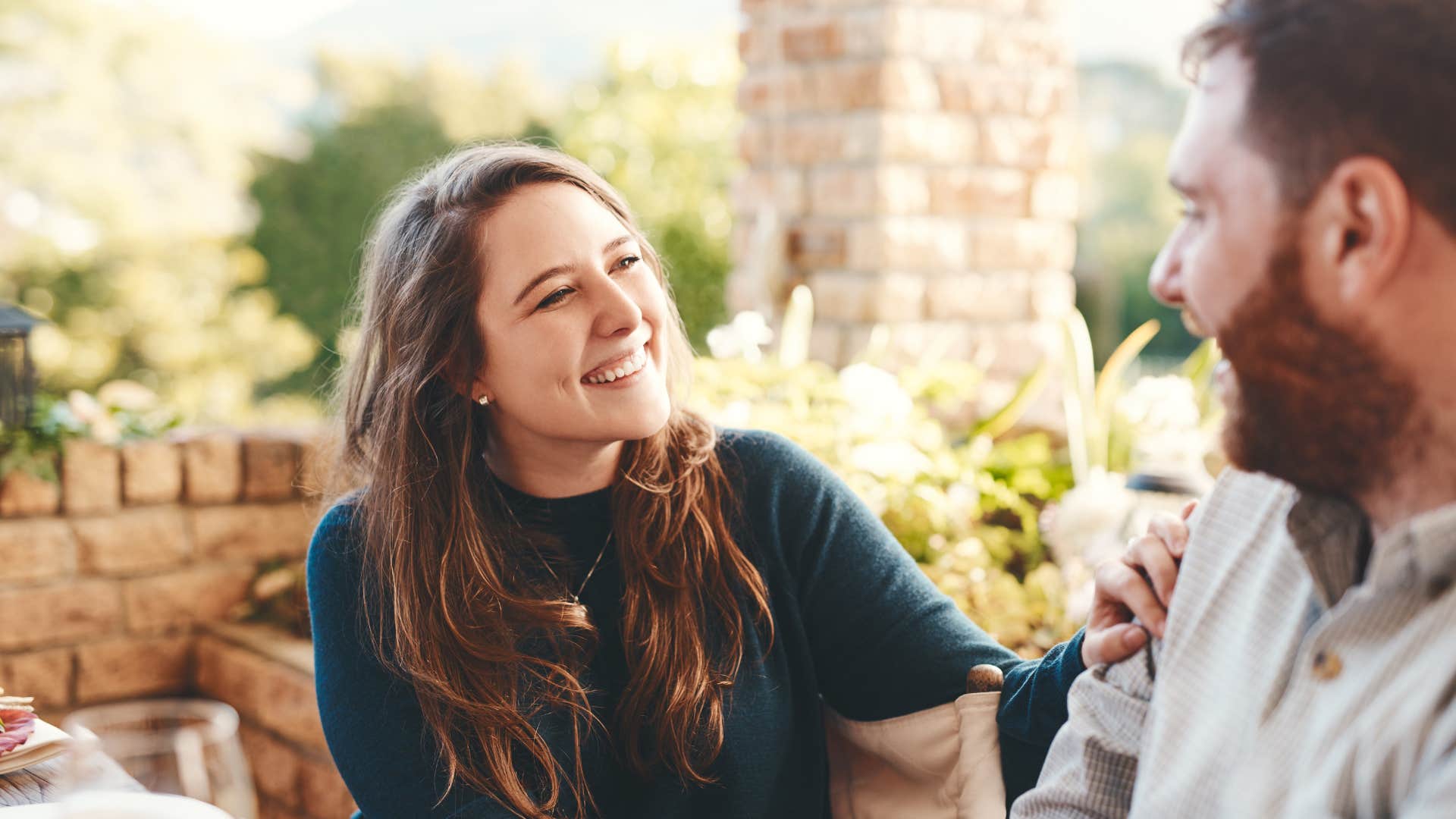 woman in green shirt smiling at man as she feels a sense of security 
