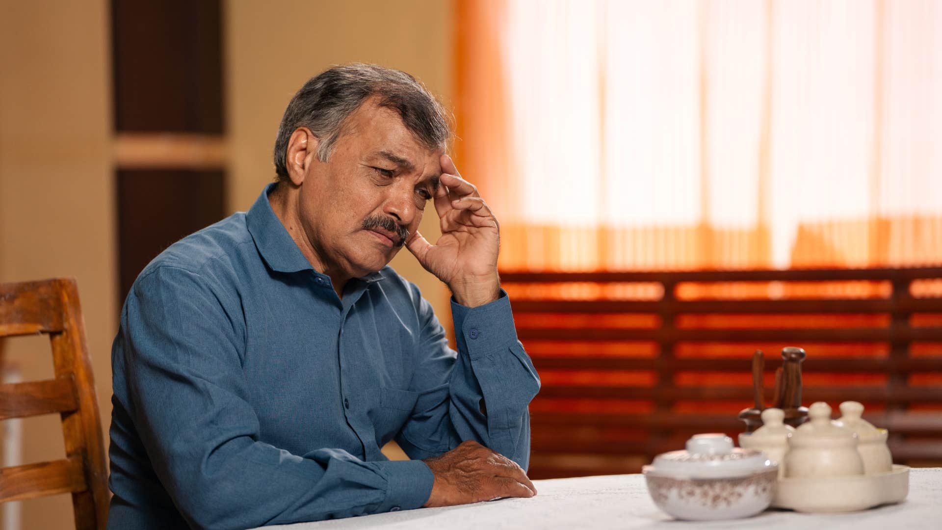 man thinking sitting at home alone