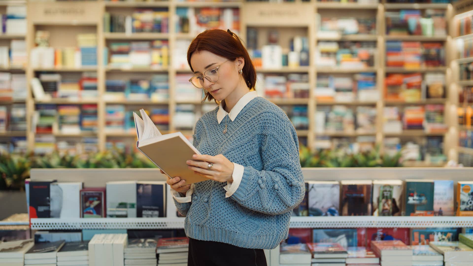 woman in blue sweater reading book as she's introverted