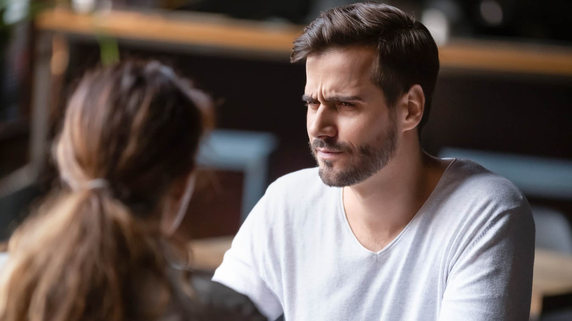 man in white shirt looking at woman confused as he's sensitive to other people's energies