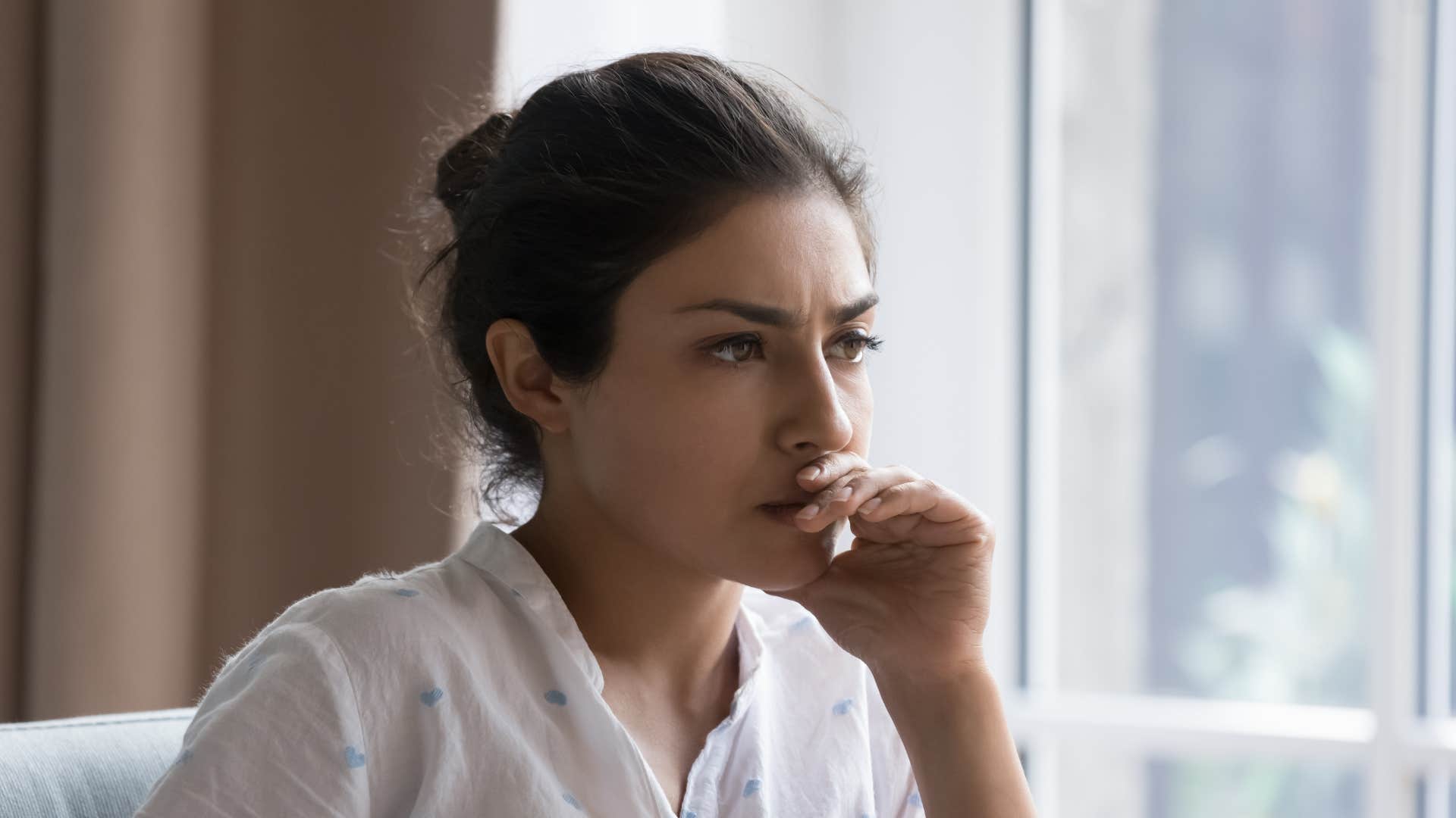 woman in white shirt anxious and socially nervous as she thinks deeply
