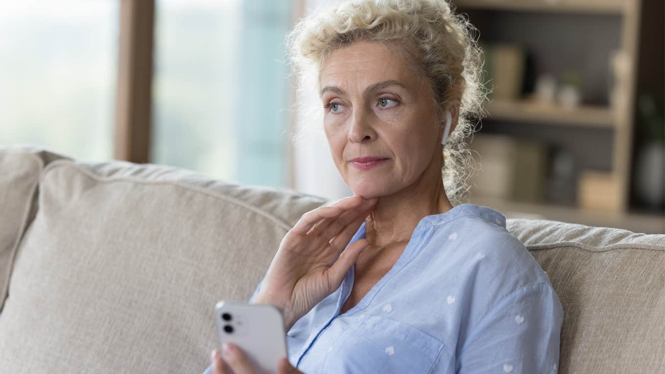 older woman at home canceling plans on her phone