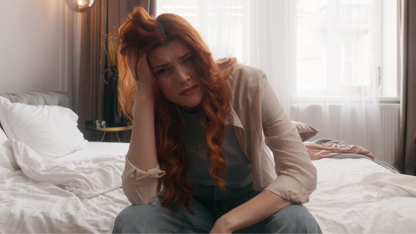 stressed woman sitting in bed early at night looking fearful