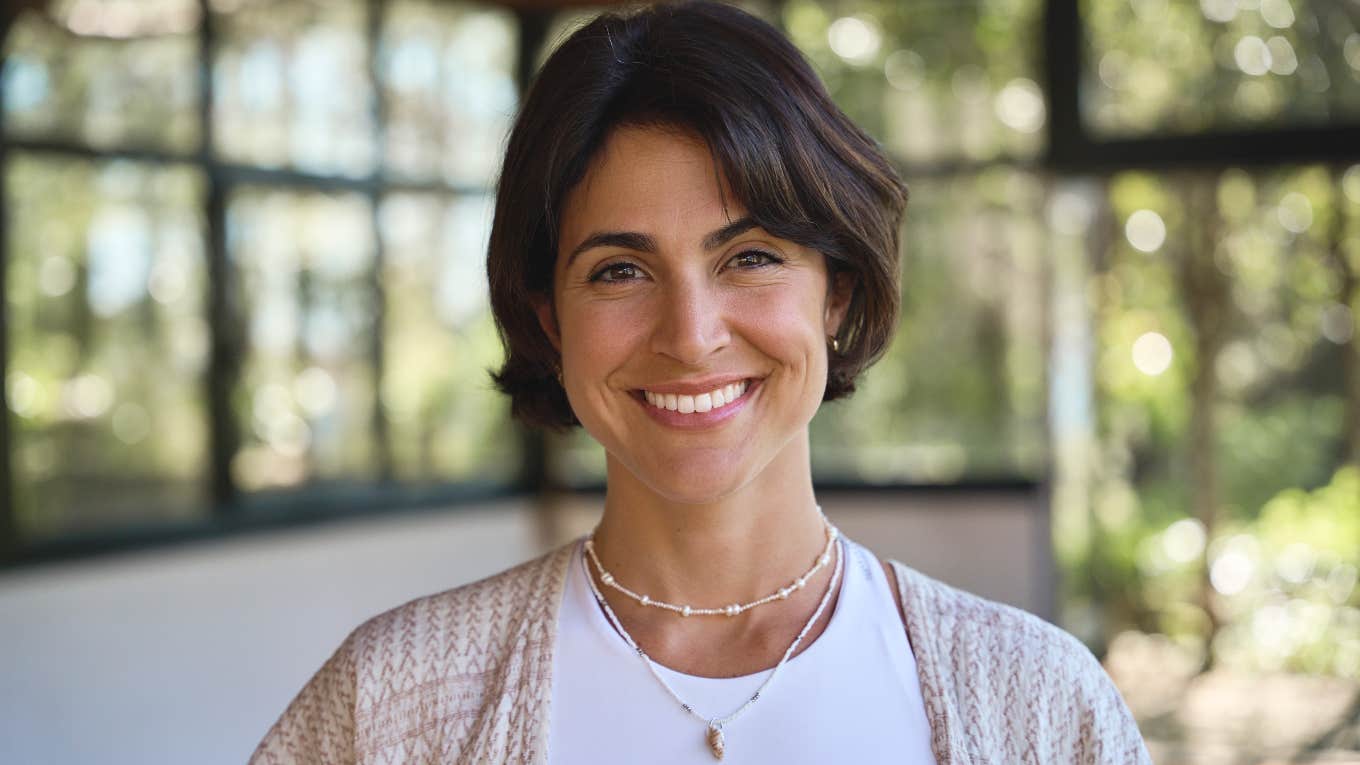 smiling woman practicing astrology and manifesting