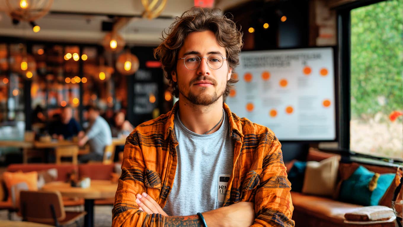 Arrogant man standing with his arms crossed, illustrating the quietly superior body language and dominant behaviors linked to people with a ‘Superman Complex.’