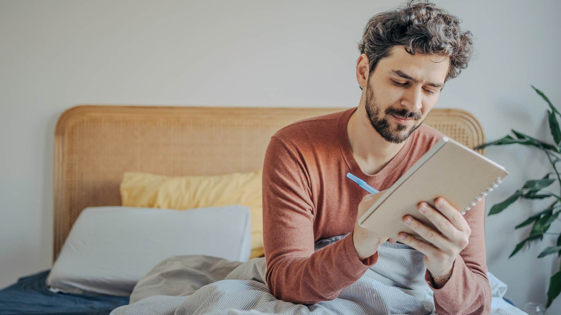 Man who appreciates emotional stability journaling at home.