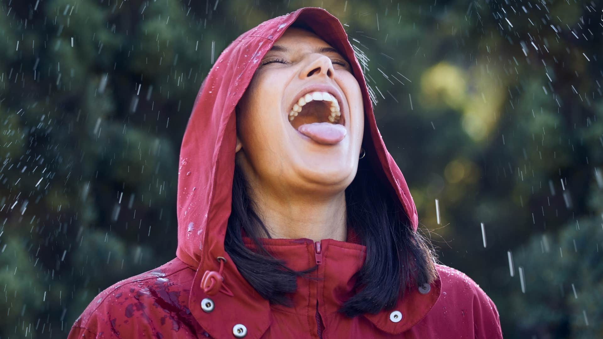 Woman who's connected to nature smiling in the rain.
