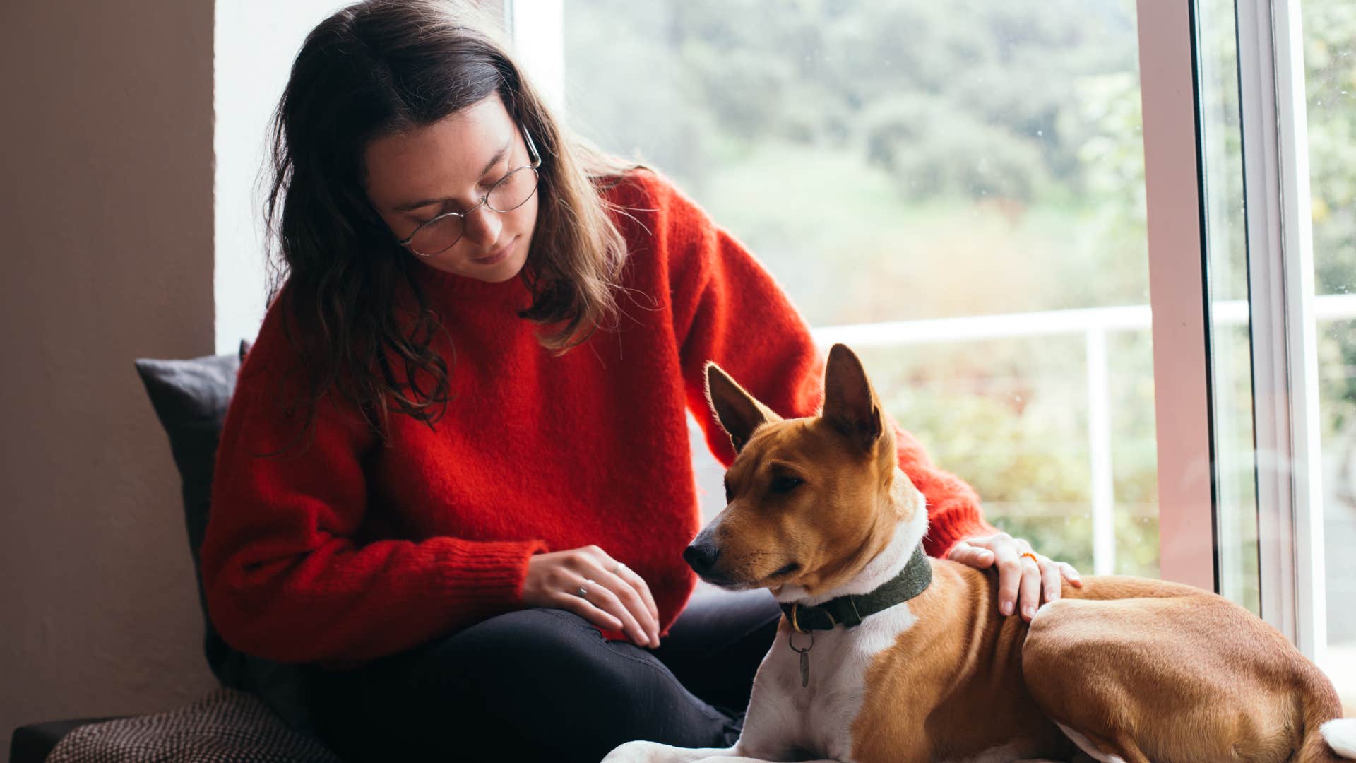 Woman who rests without guilt sitting with her dog inside.
