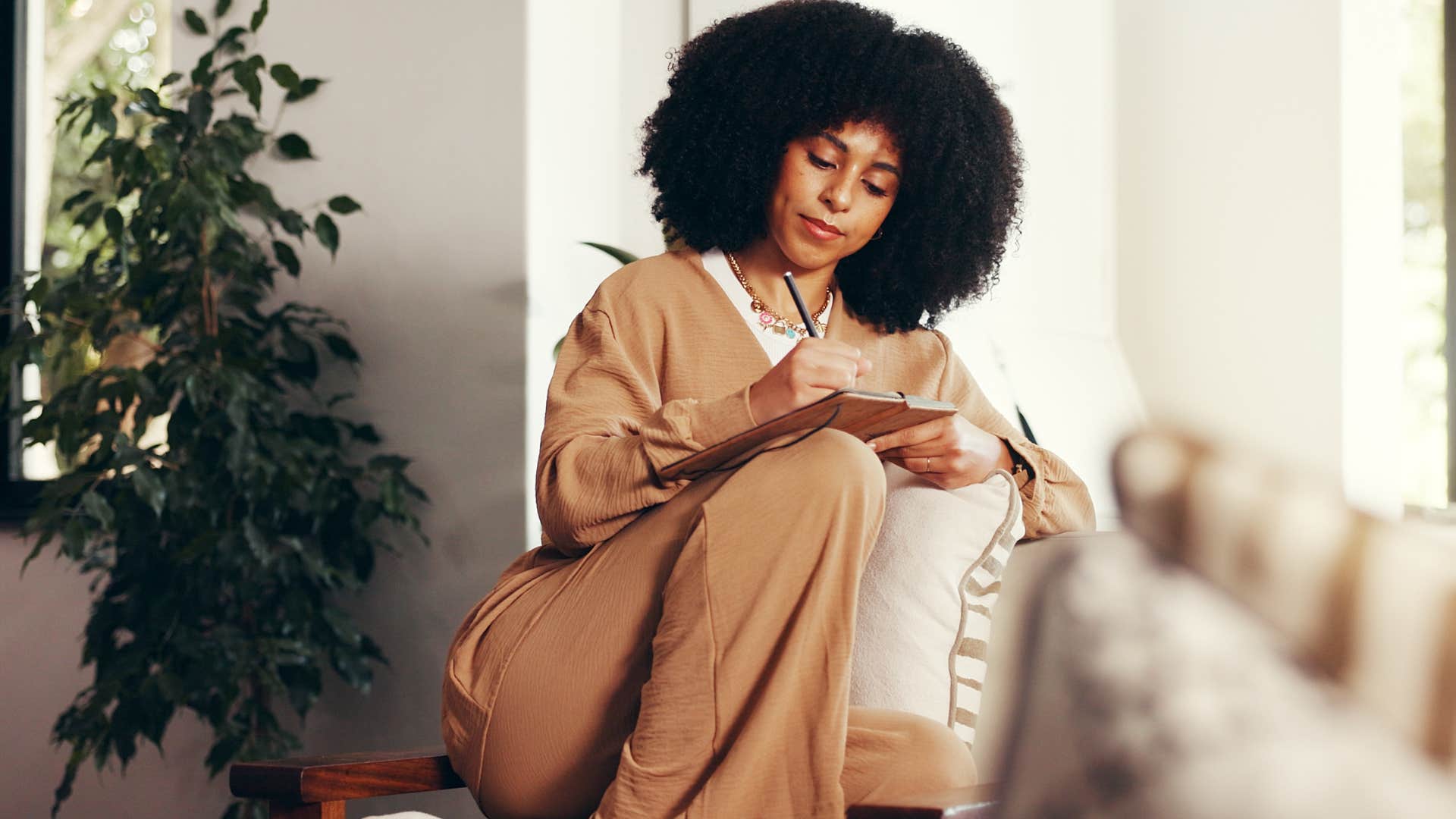 Woman who's very creative writing at home.