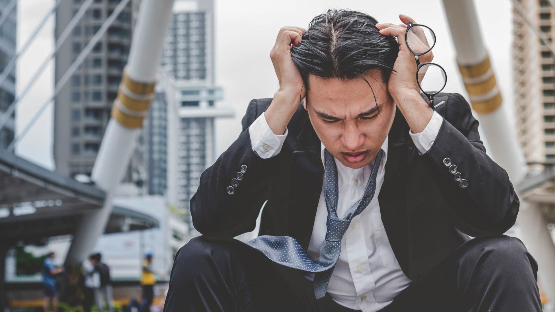 upset man sitting on the street curb