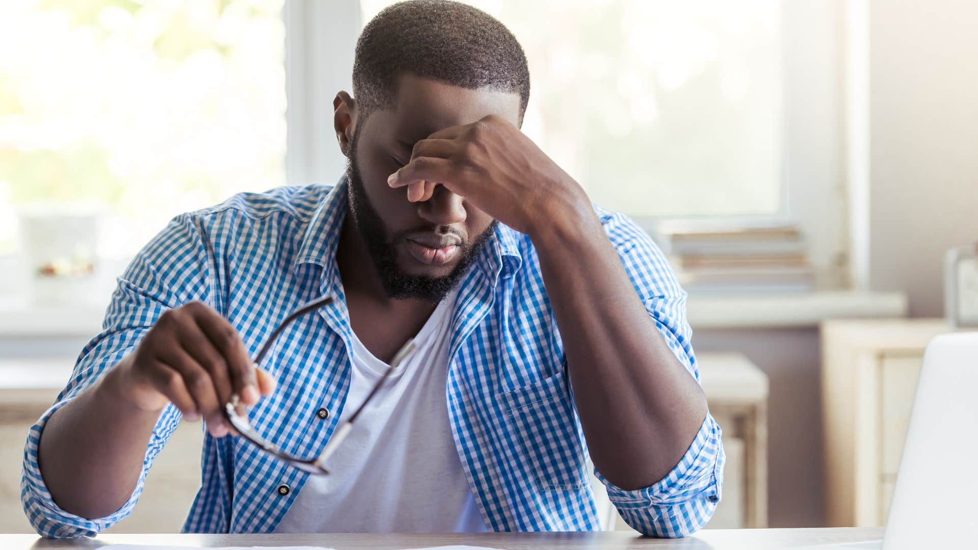 burnt out man rubbing his eyes