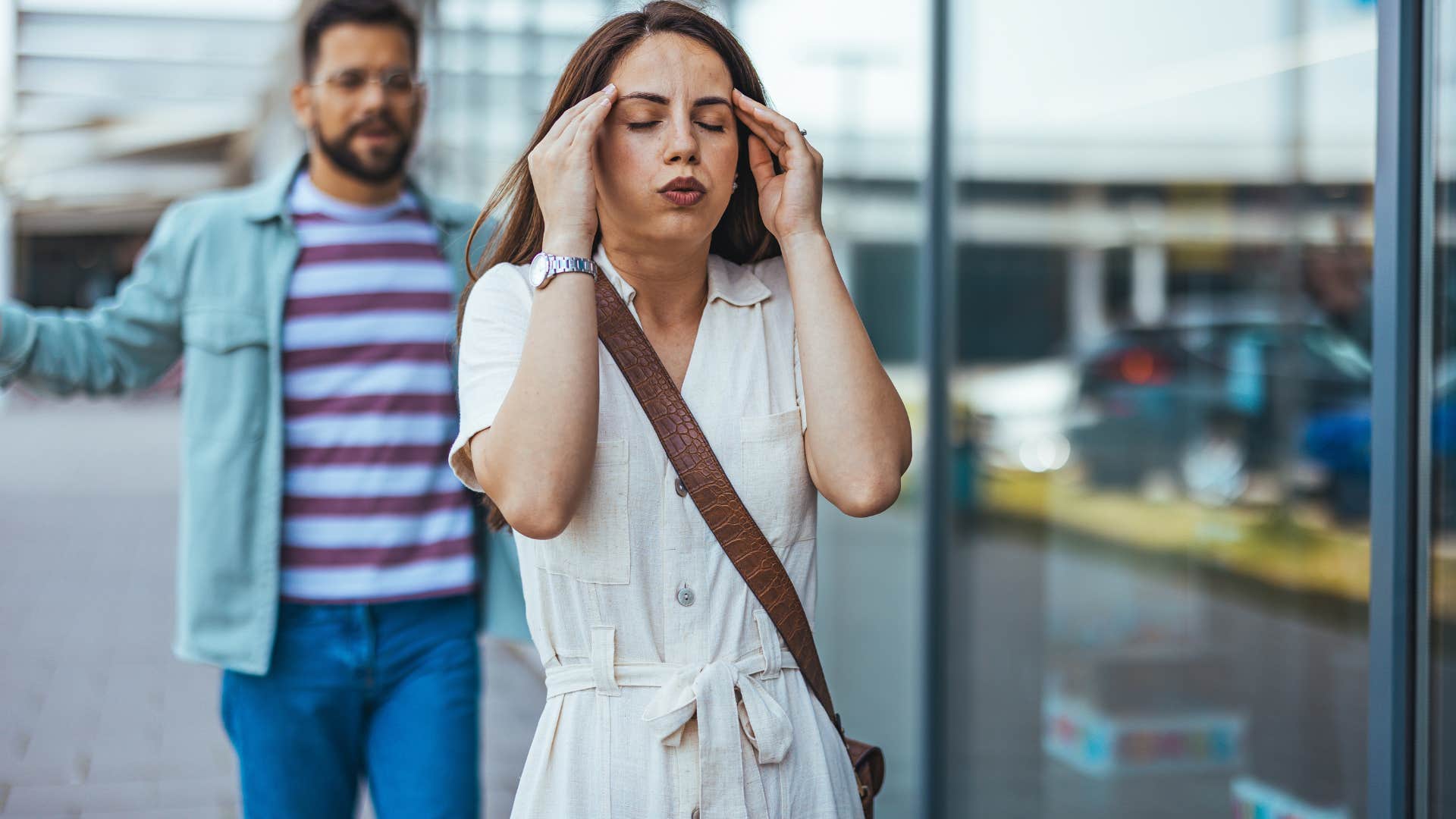 overstimulated woman walking away from partner outside