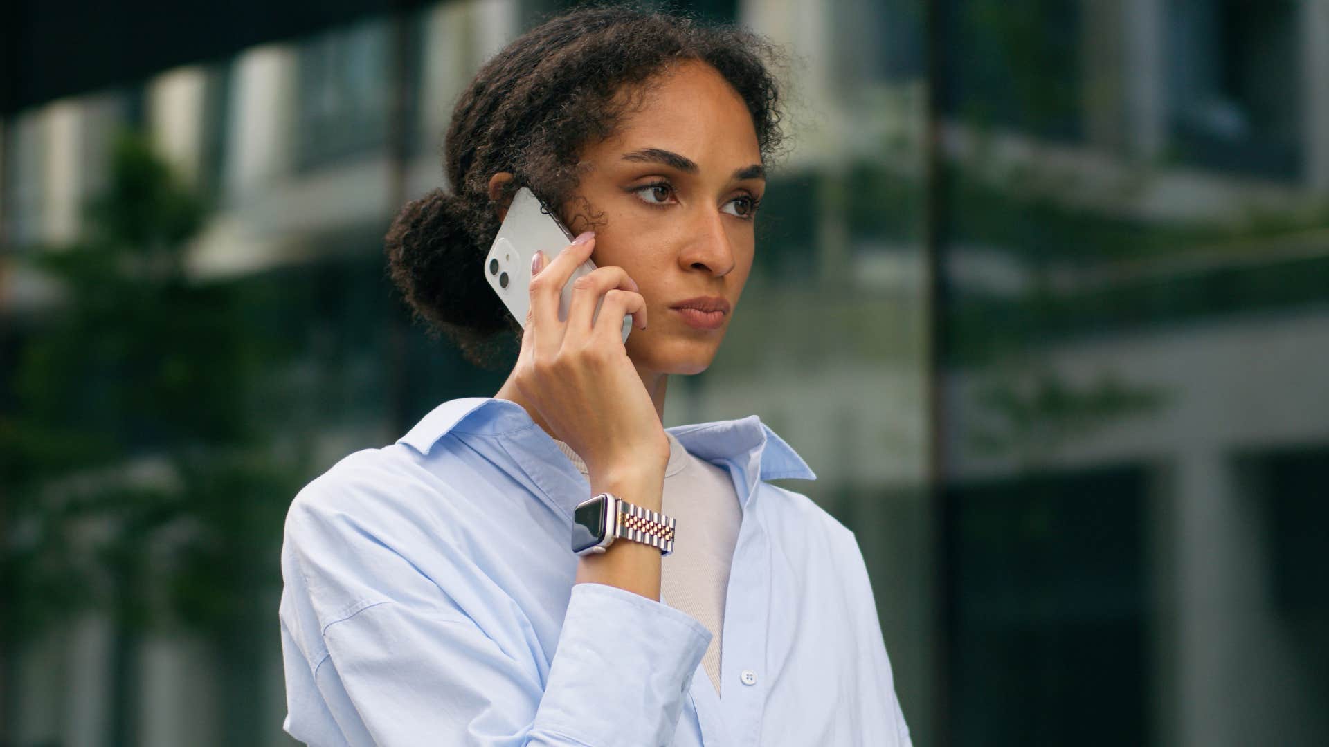 secretly competitive woman sternly talking on phone