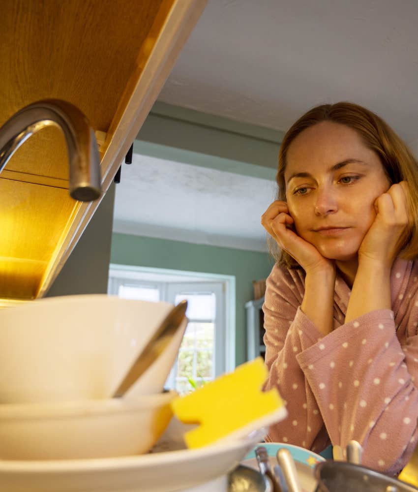 Procrastinator stares at dishes they will get around to