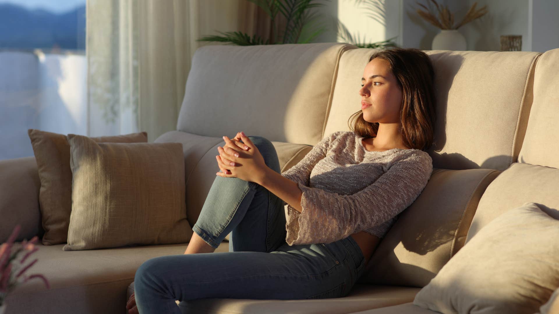 introspective woman thinking on the couch