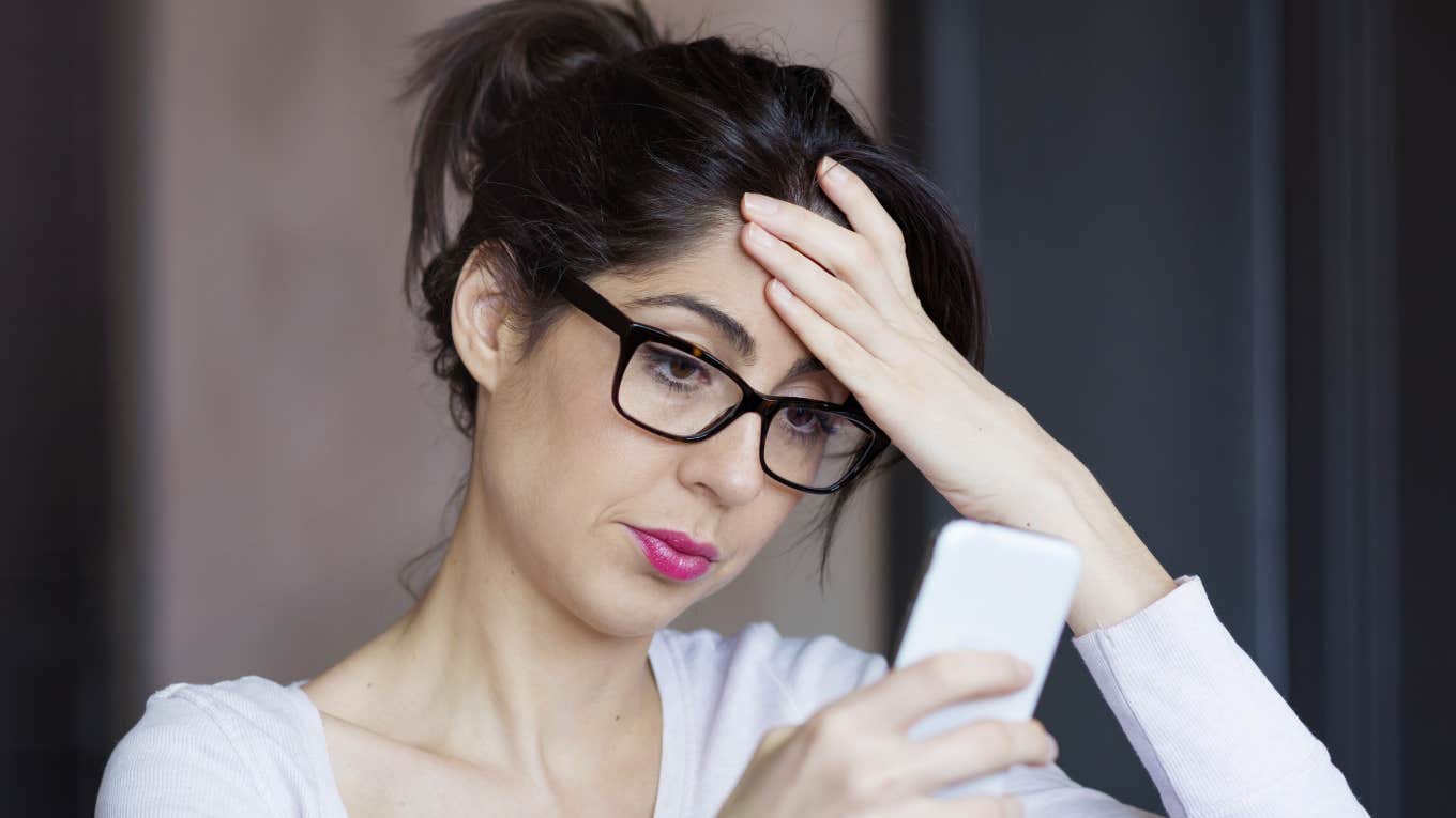 woman looking at phone dreading a call from her parents