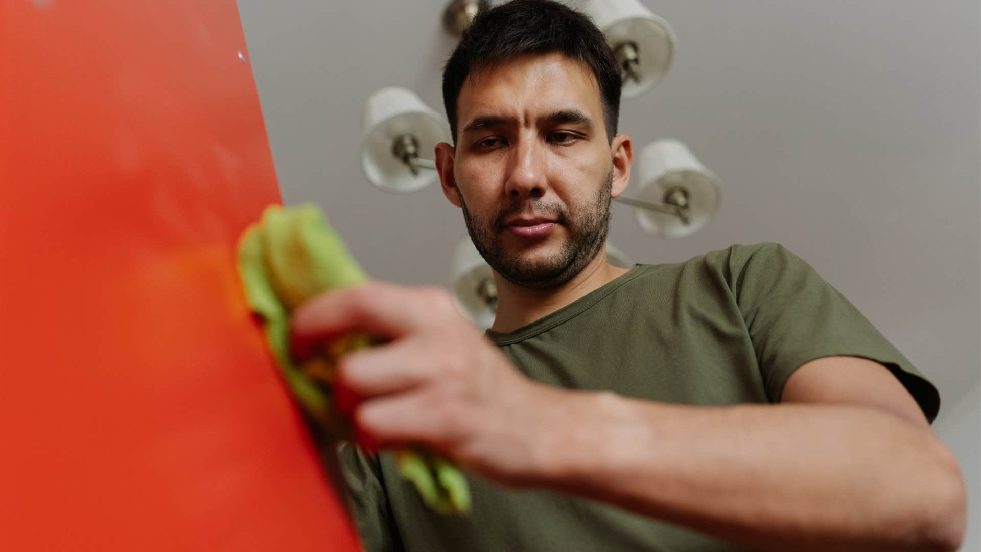 man who feels pressured to be tidy cleaning at home