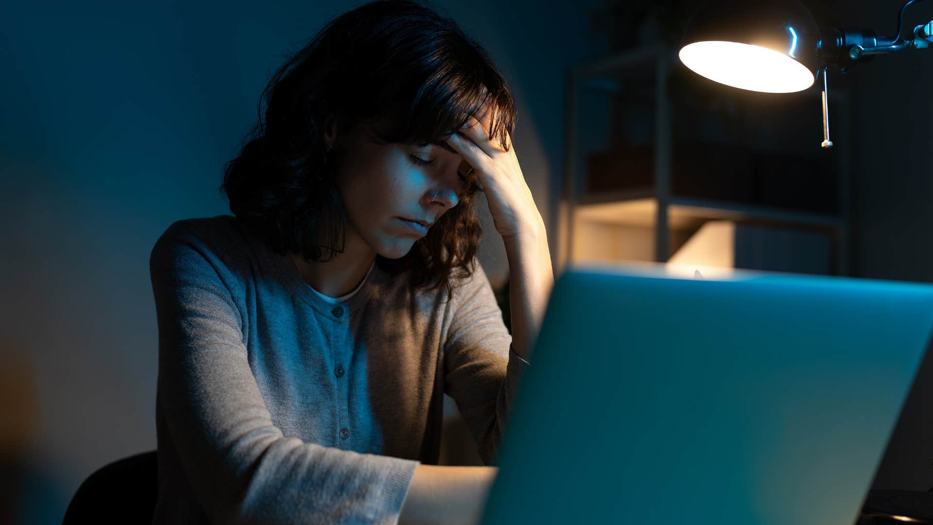 woman dealing with exhaustion working on her laptop