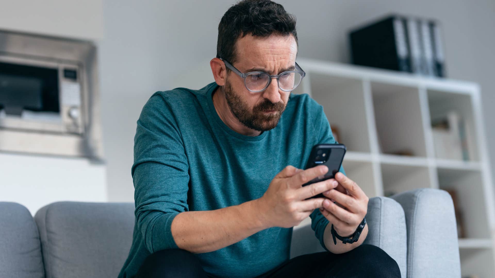 man with a fear of missing out looking at his phone