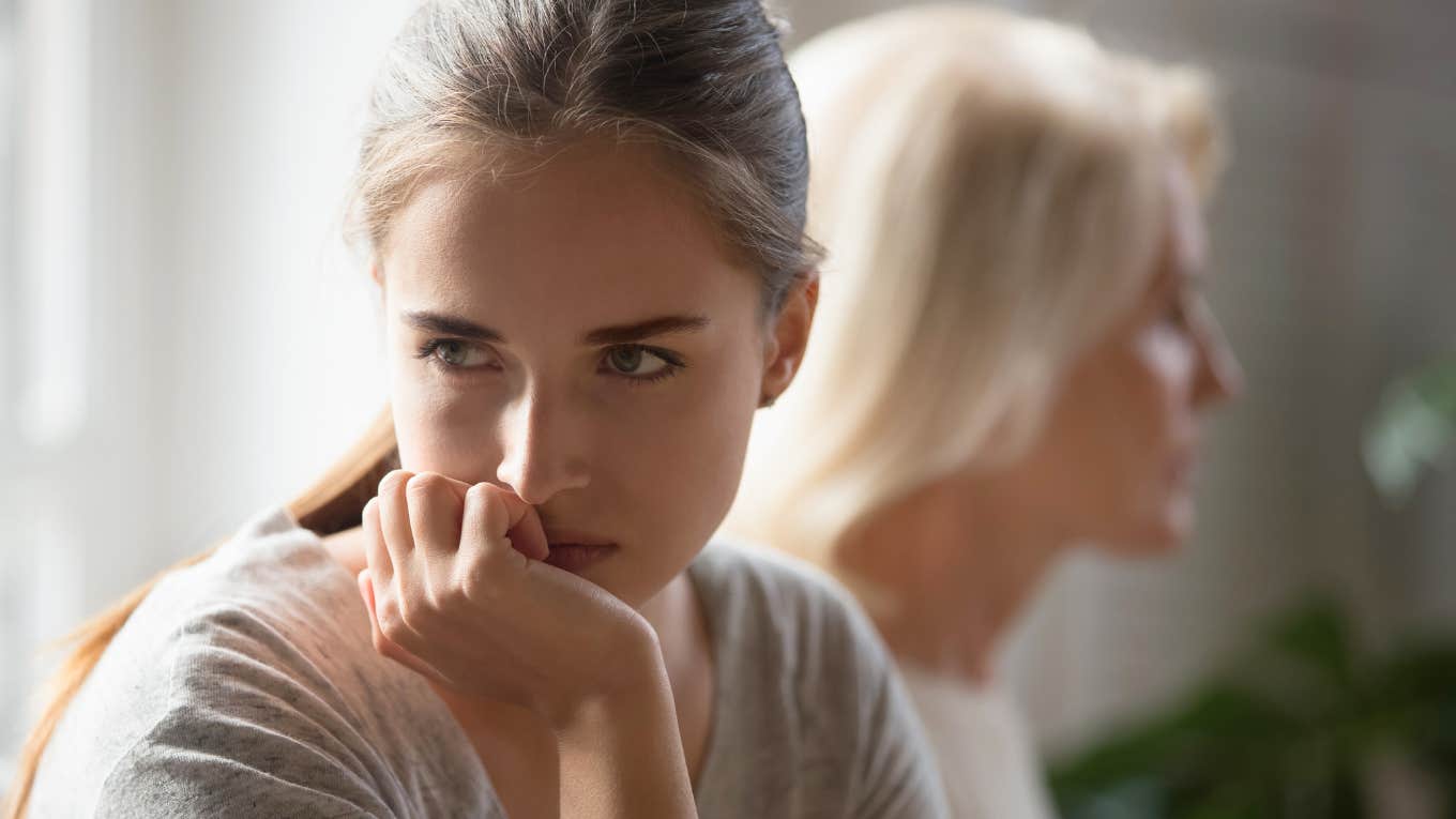 adult woman visiting her mom out of obligation and looking annoyed