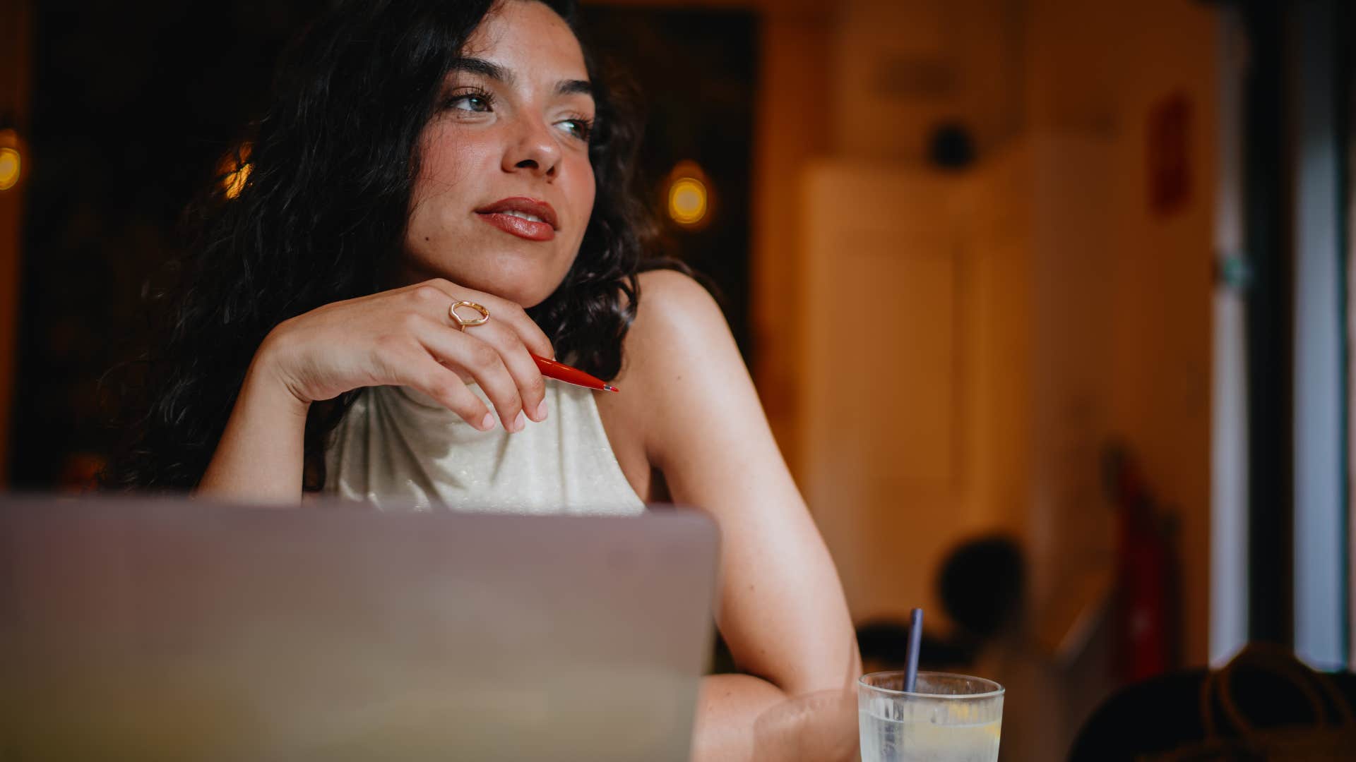 woman thinking while sitting in front of laptop