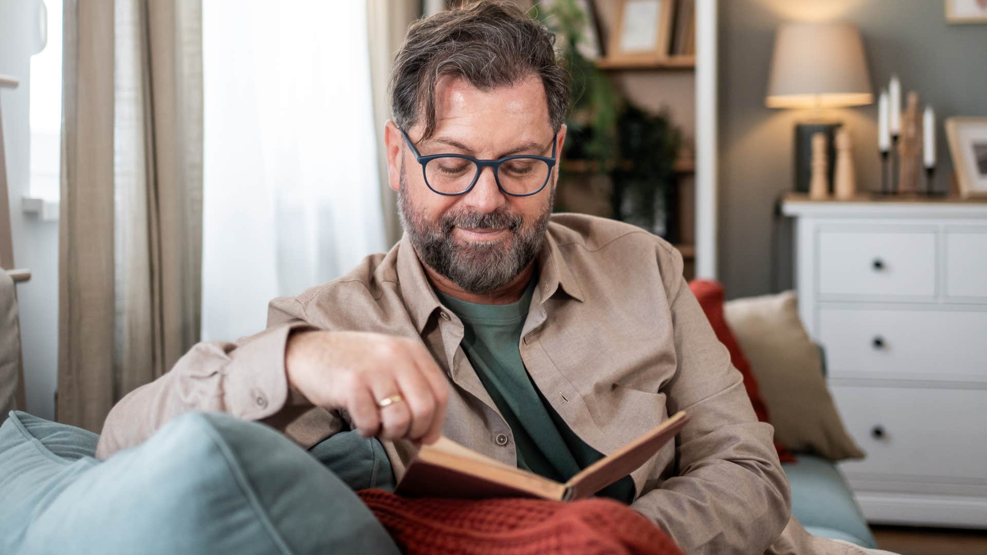 Man who's accustomed to the quiet sitting at home reading.
