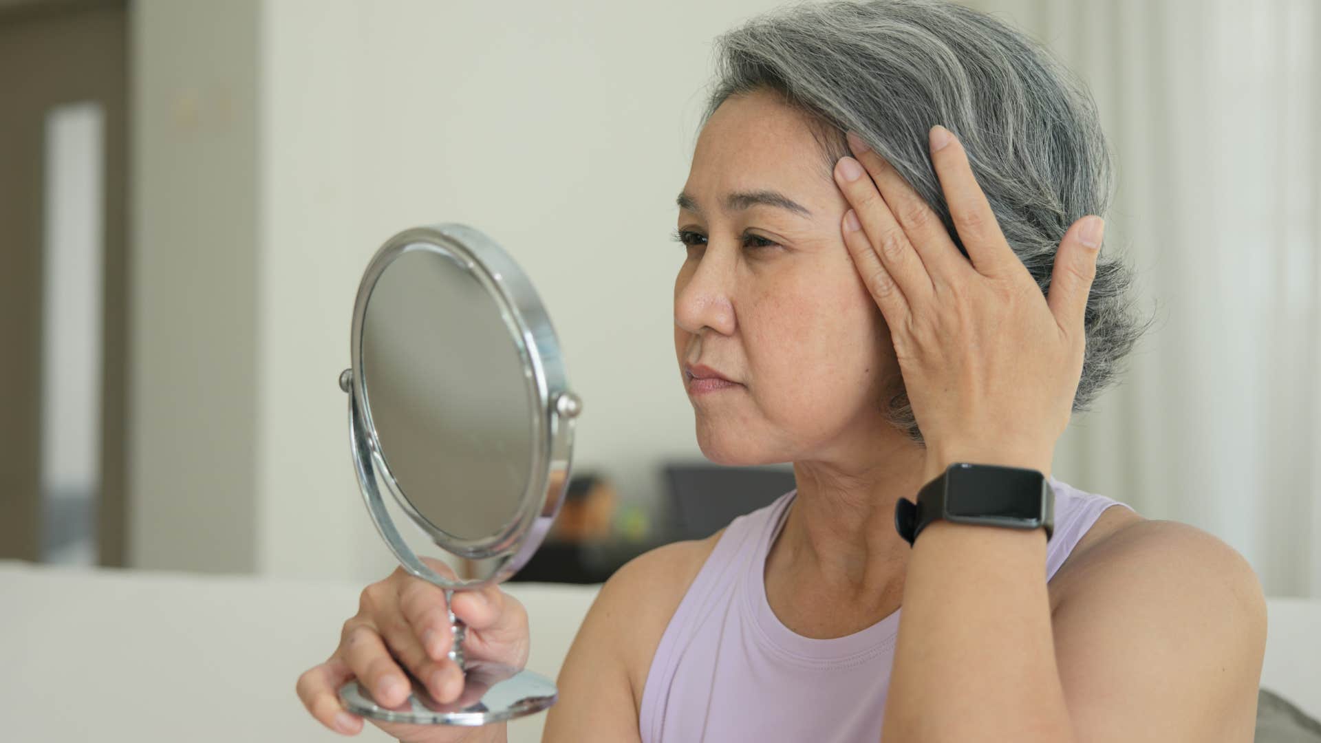 insecure woman looking in a mirror at home