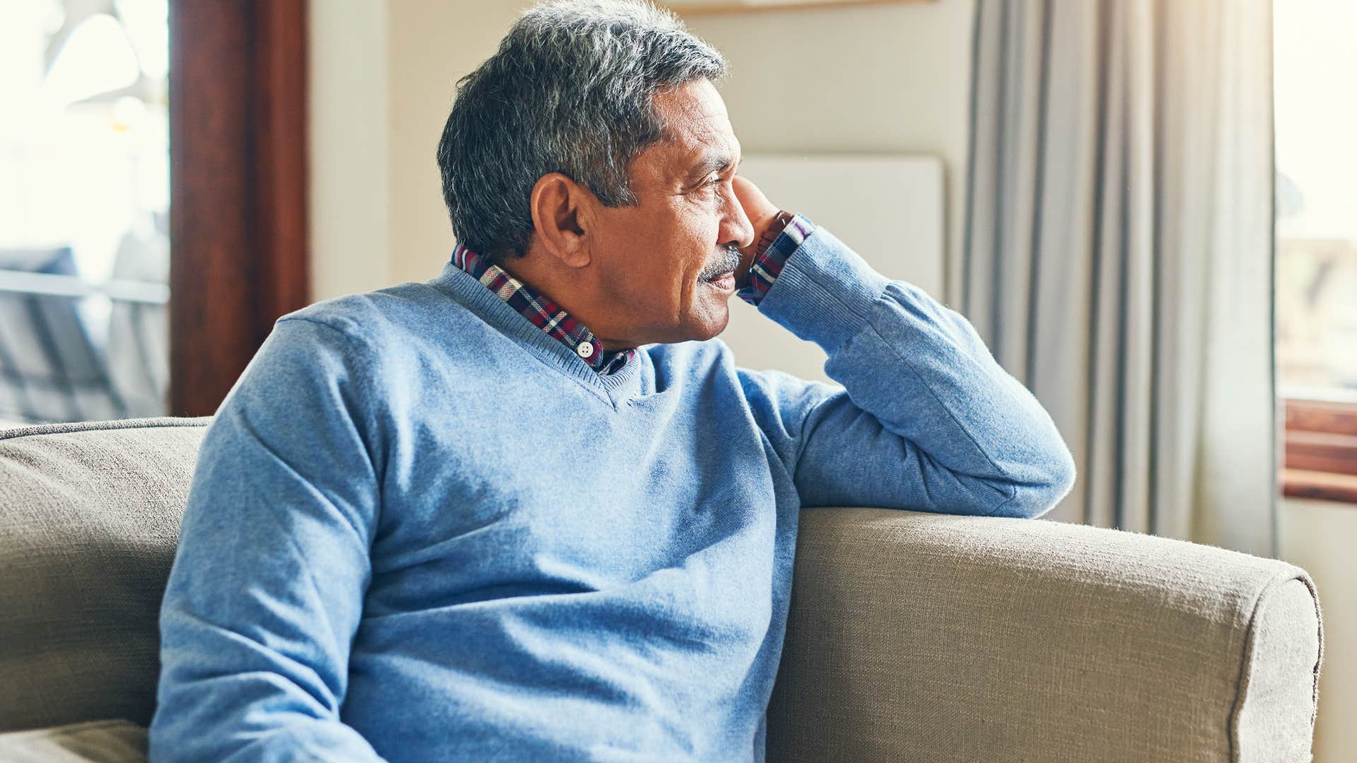 lonely older man sitting by himself at home